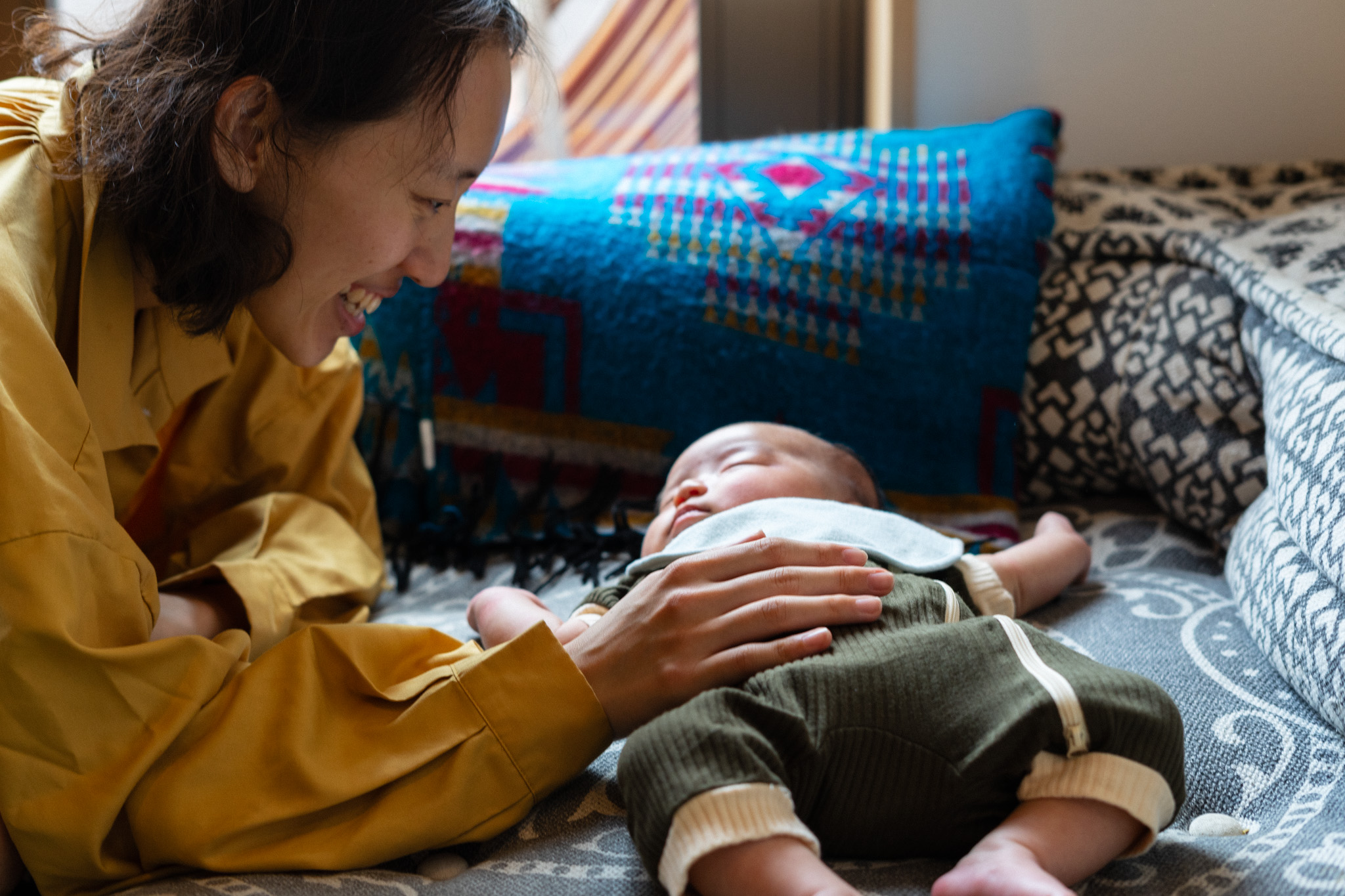 ソファで赤ちゃんを見つめる母